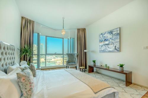 Burj Residences T3 Premium Apartment في دبي: غرفة نوم بسرير ونافذة كبيرة