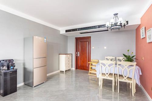 a kitchen and a dining room with a table and chairs at Cloud & Sea Boutique Apartment in Rizhao