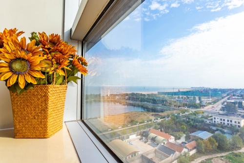 a vase filled with flowers sitting on a window sill at Cloud & Sea Boutique Apartment in Rizhao