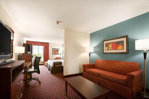 a hotel room with a couch and a desk at Wingate by Wyndham San Marcos in San Marcos