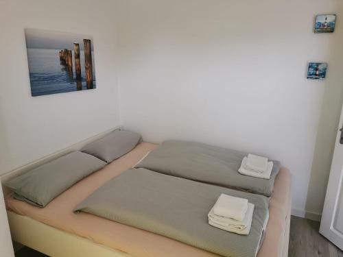 a bedroom with a bed with two towels on it at FeWo Meerblick - Schillig in Schillig