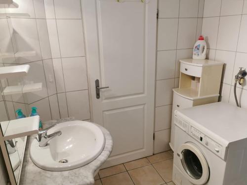 a bathroom with a sink and a washing machine at FeWo Meerblick - Schillig in Schillig