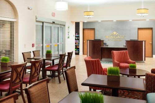 a restaurant with tables and chairs and a bar at Wingate by Wyndham San Marcos in San Marcos