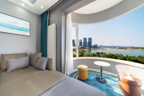 a living room with a couch and a large window at Cloud & Sea Boutique Apartment in Rizhao