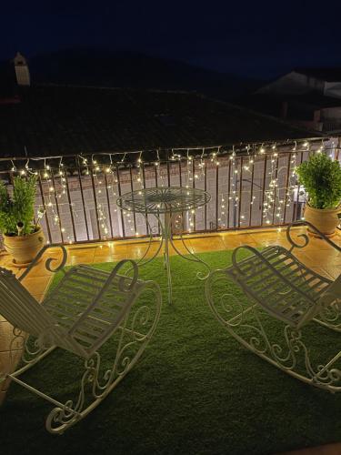 a patio with two chairs and a table and lights at El Comercio in Villarejo del Valle