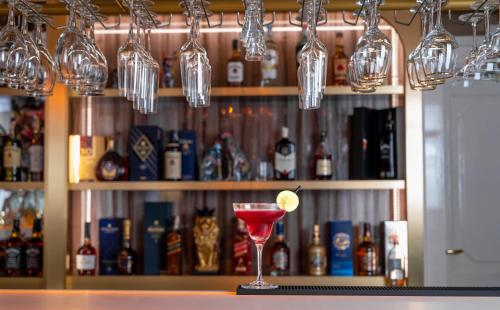 a drink in a martini glass sitting on a bar at Queen Palace in Novi Sad