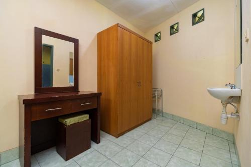 a bathroom with a sink and a mirror at Urbanview Hotel Griya Astoeti 2 Cisarua Puncak in Kopo 2