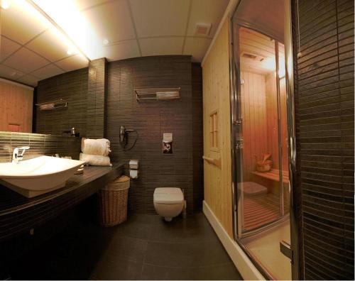 een badkamer met een wastafel, een toilet en een douche bij Elysion Hotel in Mytilini