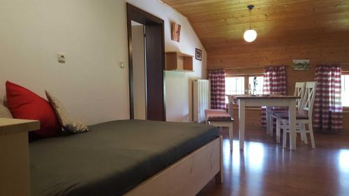 a bedroom with a bed and a kitchen with a table at Hof Rossruck in Fischbachau