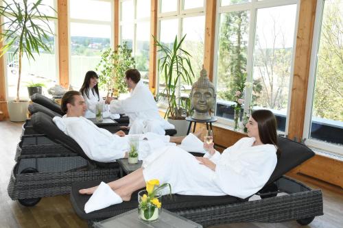 a group of people sitting in white robes in a room at Vitalhotel Strobl in Ollersdorf im Burgenland