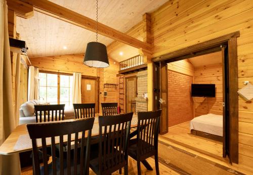 a dining room with a table and chairs and a bedroom at Ruhnu Holiday House in Ruhnu