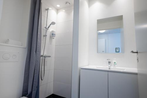 baño blanco con ducha y lavamanos en Severin en Middelfart