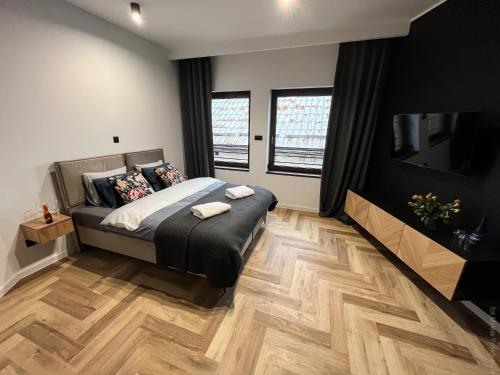 a bedroom with a bed and a flat screen tv at Apartamenty Warowna 2 in Pszczyna