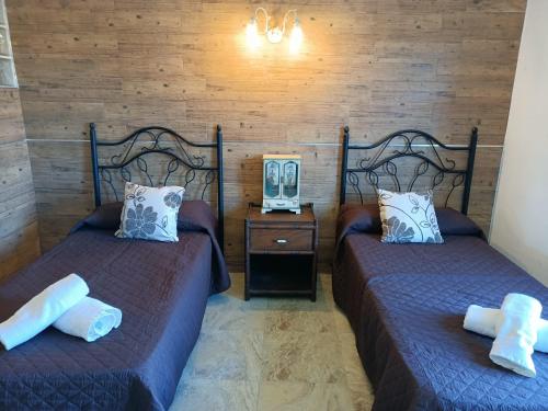 ein Schlafzimmer mit 2 Betten und einem Tisch mit einem Nachttisch in der Unterkunft CASA RURAL CORTIJO MOLINO EL TARAHAL in El Tarahal
