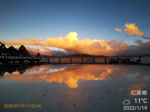 a reflection of a cloudy sky in a pool of water at Naluwan Villa in Renai