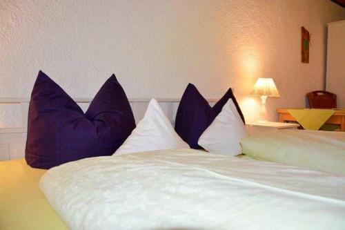 a bed with blue pillows on top of it at Hof Rossruck in Fischbachau