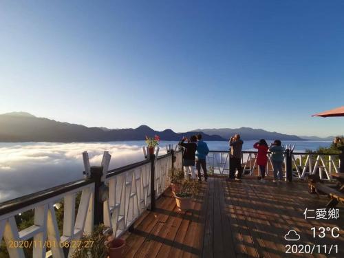 a group of people standing on a deck looking out at the water at Naluwan Villa in Renai