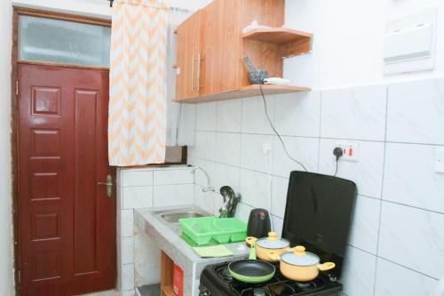 a kitchen with a stove with pots and pans on it at Lux Suites Carina Casey Apartments Bamburi in Bamburi