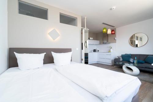 シャルボイツにあるFerienwohnung Capolino Suiteのベッドルーム(大きな白いベッド1台付)、リビングルームが備わります。