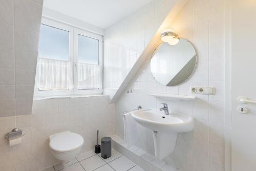 a bathroom with a sink and a toilet and a mirror at Ferienwohnung Die 25 in Timmendorfer Strand