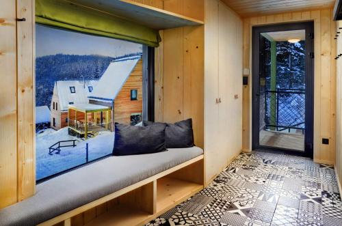 a window seat in a tiny house with a view at Chaty Tri vydry in Tale