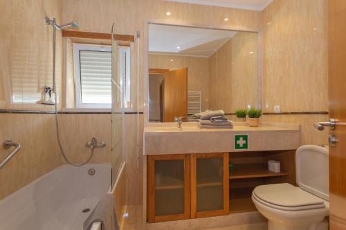 La salle de bains est pourvue d'une baignoire, de toilettes et d'un lavabo. dans l'établissement Luxe villa Sesimbra secret corner 2, à Sesimbra