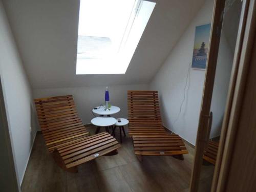 Habitación con 2 sillas, mesa y ventana en komfortables Ferienhaus Allee, en Krummin