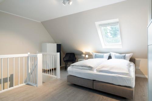 - une chambre avec un lit blanc et une fenêtre dans l'établissement Ferienwohnung Hygge, à Timmendorfer Strand