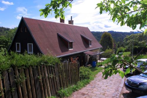 een zwart huis met een rood dak en een hek bij Wellness Chaloupka Mezná - Národní park České Švýcarsko in Hřensko