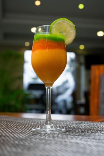 a drink with a lime in a glass on a table at Saffron Hotel Unawatuna in Unawatuna