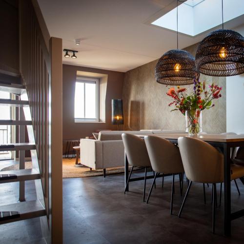 a dining room with a table and chairs and a couch at Parc Maasresidence Thorn Apartments in Thorn