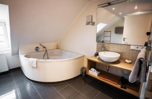 a bathroom with a large tub and a sink at Hotel & Restaurant Rizzelli Superior in Neustadt an der Aisch