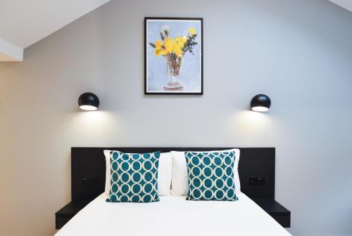 a bedroom with a bed with blue and white pillows at New Cavendish Street Serviced Apartments by StayPrime in London