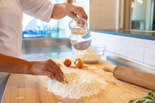 a chef is mixing ingredients on a cutting board at UNAHOTELS Imperial Sport Hotel in Pesaro