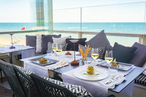 a table with plates of food and glasses of wine at UNAHOTELS Imperial Sport Hotel in Pesaro