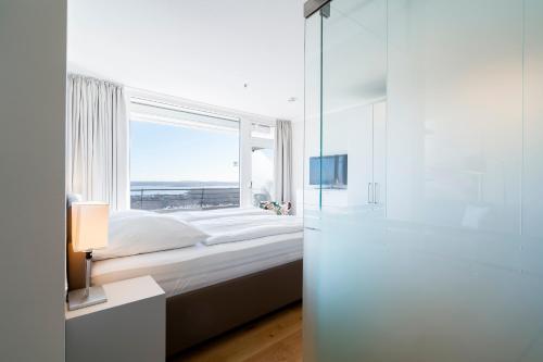 トラフェミュンデにあるFerienwohnung Nordermoleのベッドと大きな窓のある寝室