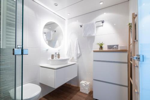 トラフェミュンデにあるFerienwohnung Nordermoleの洗面台とトイレを備えた白いバスルーム