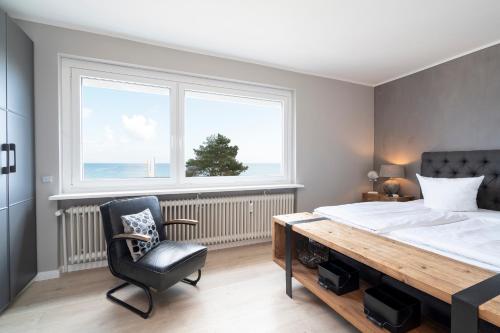 Schlafzimmer mit einem Bett, einem Schreibtisch und einem Stuhl in der Unterkunft Ferienwohnung Puro Suite in Scharbeutz