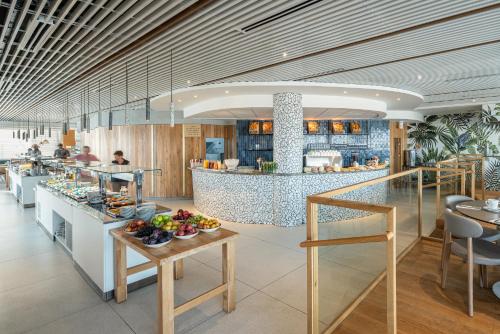 a restaurant with a counter with food on it at Carlton Tel Aviv Hotel – Luxury on the Beach in Tel Aviv