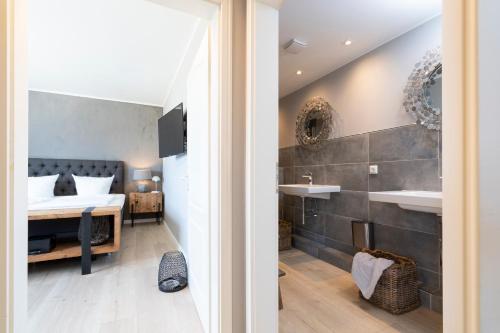 ein Schlafzimmer mit einem Bett und ein Badezimmer mit einem Waschbecken in der Unterkunft Ferienwohnung Puro Suite in Scharbeutz