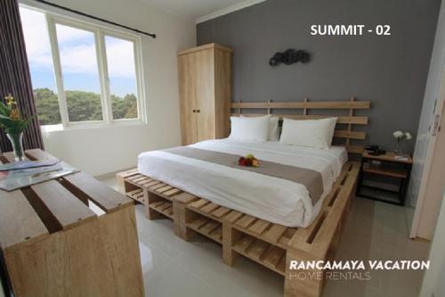 a bedroom with a large bed with a wooden frame at R Hotel Rancamaya in Bogor