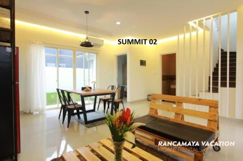 a dining room and living room with a table and chairs at R Hotel Rancamaya in Bogor