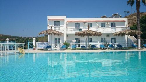 a large swimming pool in front of a hotel at Angelina Studios in Kardamaina