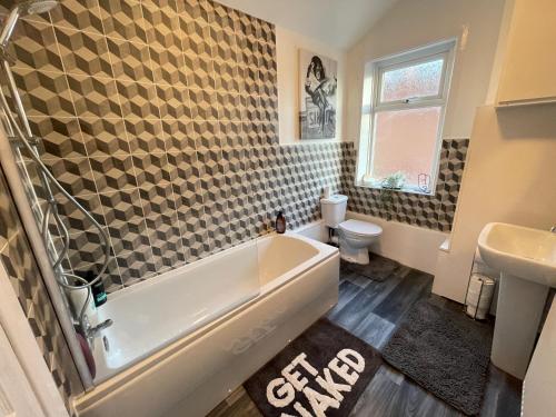 a bathroom with a tub and a toilet and a sink at Urban 3 Bedroom Home in Kings Heath-Great Location in Birmingham