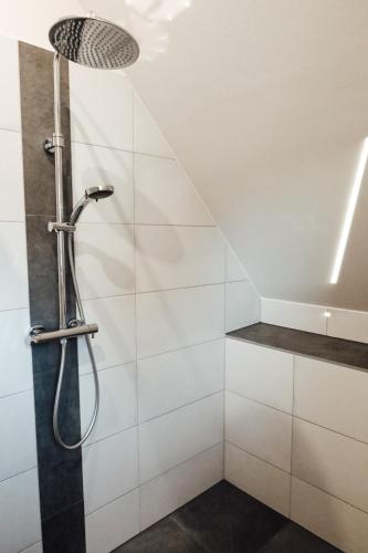 a shower in a bathroom with white tiles at Vulkanland Stoeckel - Feldbach in Feldbach
