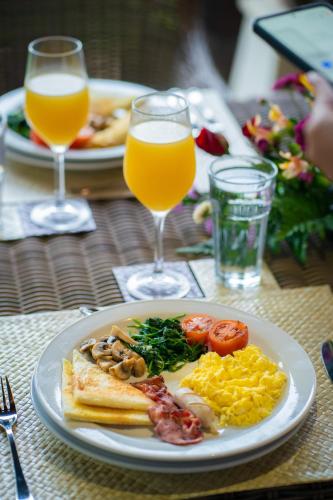 un piatto di cibo per la colazione e due bicchieri di succo d'arancia di Echo Suji Villa a Canggu