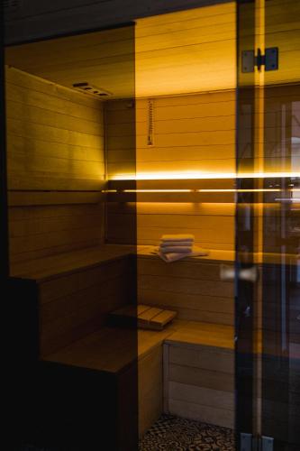 a walk in shower with wooden walls and wooden shelves at Villa Monica Apartamenty in Szczyrk