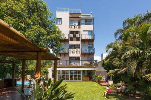 un edificio alto con un patio con un edificio en Jurerê Beira Mar Residence, en Florianópolis