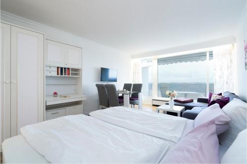 um quarto branco com uma cama branca e uma secretária em Ferienwohnung Landblick App 162 em Timmendorfer Strand