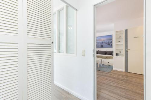 Zimmer mit weißen Wänden und Schiebetür in der Unterkunft Ferienwohnung Die 2b in Timmendorfer Strand